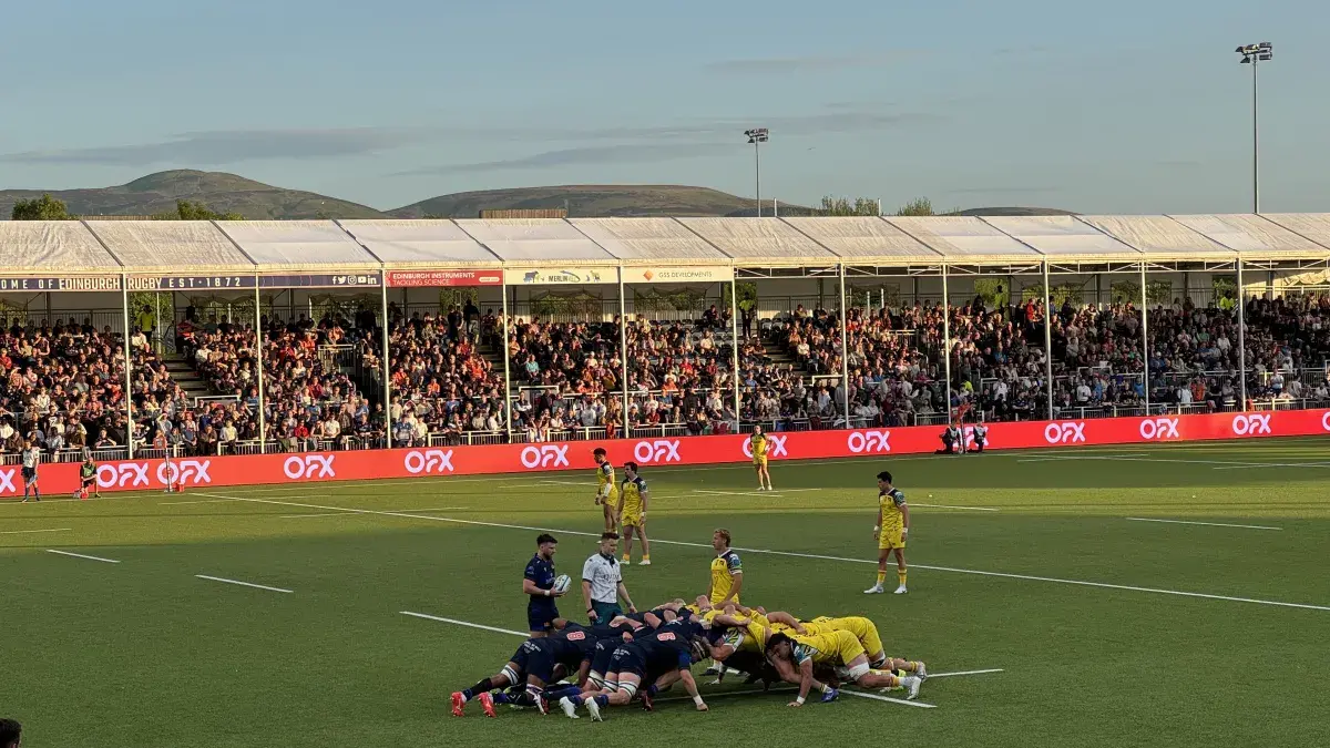 Rugby players in a scrum on the pitch at the Hive Stadium