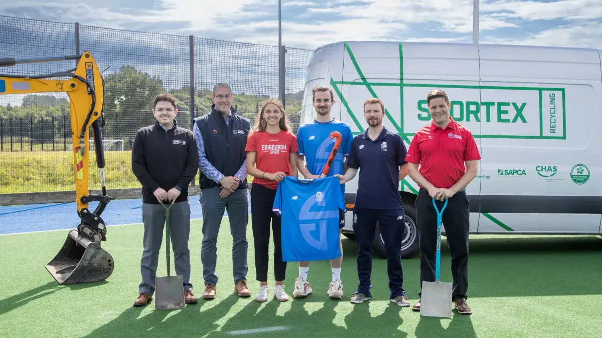 Image of staff from Sportex, Scottish Hockey and Edinburgh University on hockey pitch in front of tractor and sportex recycling van