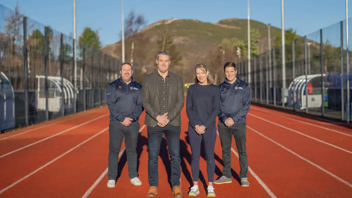 Image of Craig Bolan, Mark Munro, Eilidh Doyle and David Hughes on running track at peffermill playing fields