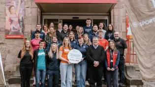 image of group of university of edinburgh staff and students and SAMH staff outside pleasance gym smiling in group photo