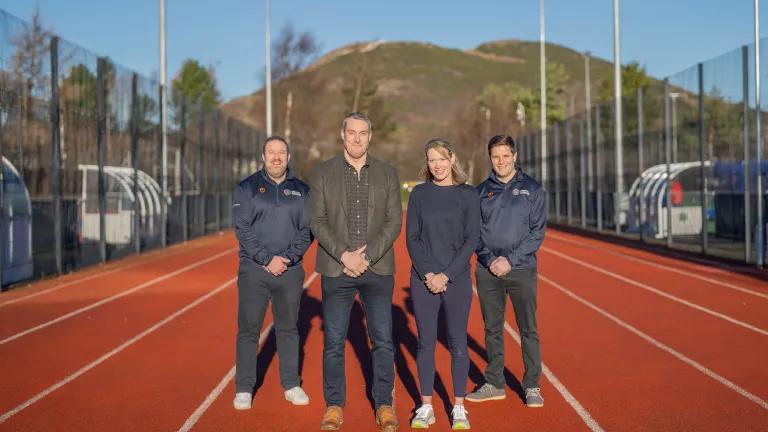 Image of Craig Bolan, Mark Munro, Eilidh Doyle and David Hughes on running track at peffermill playing fields