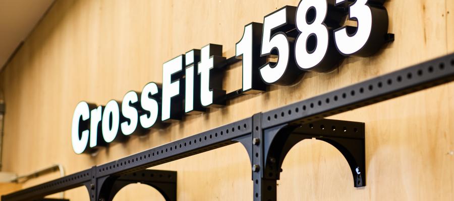 Image of Crossfit 1583 light box sign on wooden wall