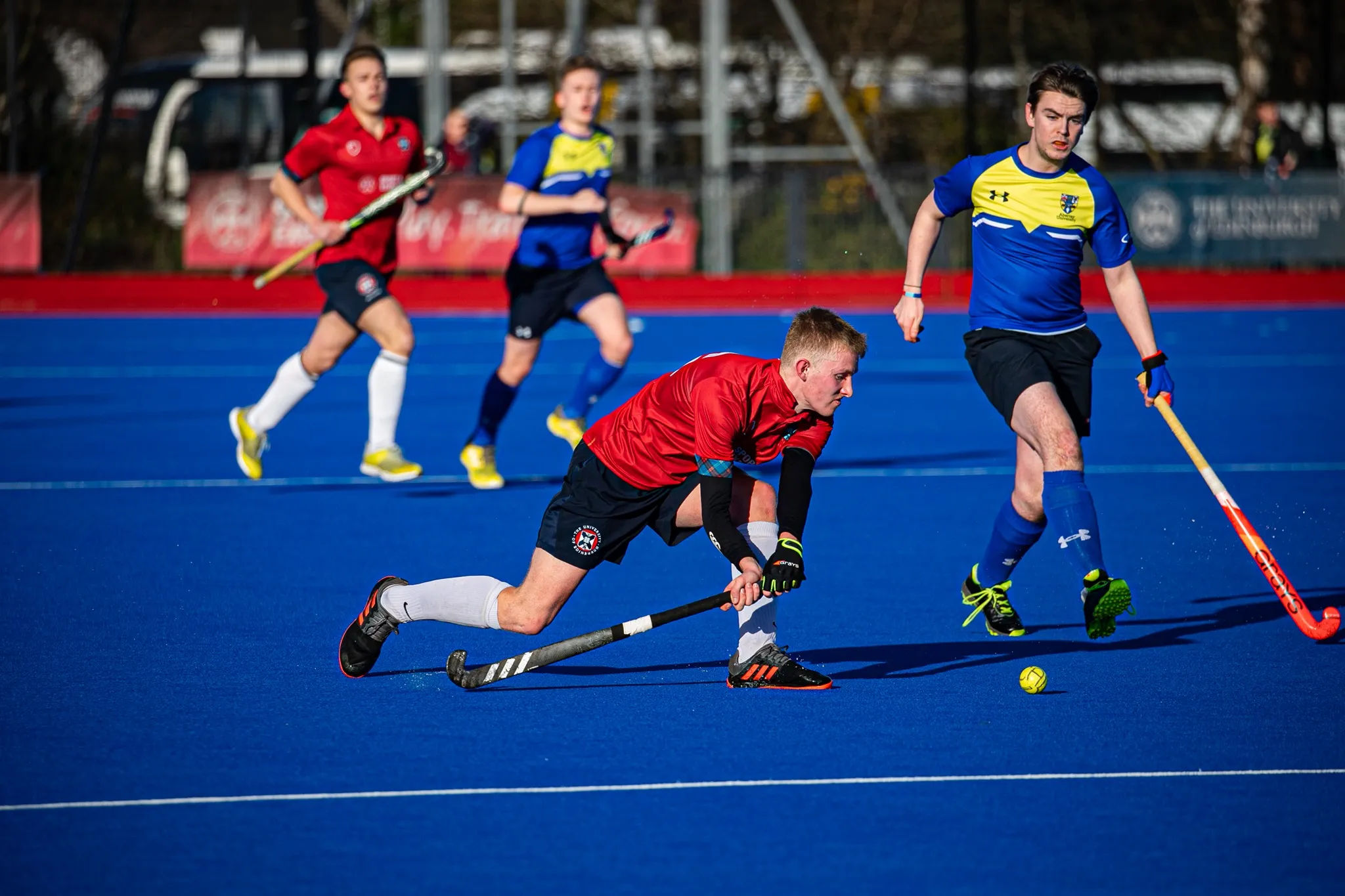 Men's Hockey player sweeping ball 