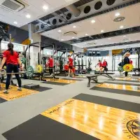 View of gym with members lifting weights in distance
