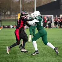 2 people playing american football, tackling each other