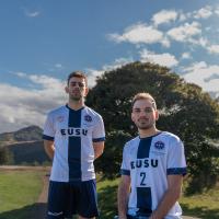 two people in sports kit with view of Edinburgh behind