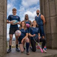 group of 5 people on calton monument holding sports equipment