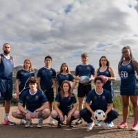 group photo on calton hill in edinburgh , 10 people in kit holding sports equipment