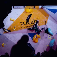 zoomed out climbing wall with woman bouldering