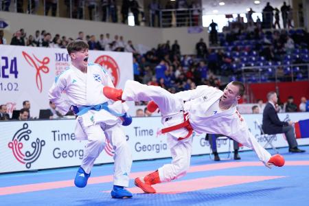 2 people wearing white gis competing in Karate