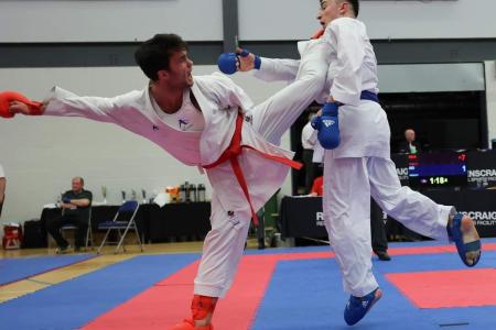 2 men competing in Karate, Antione kicking his opponent