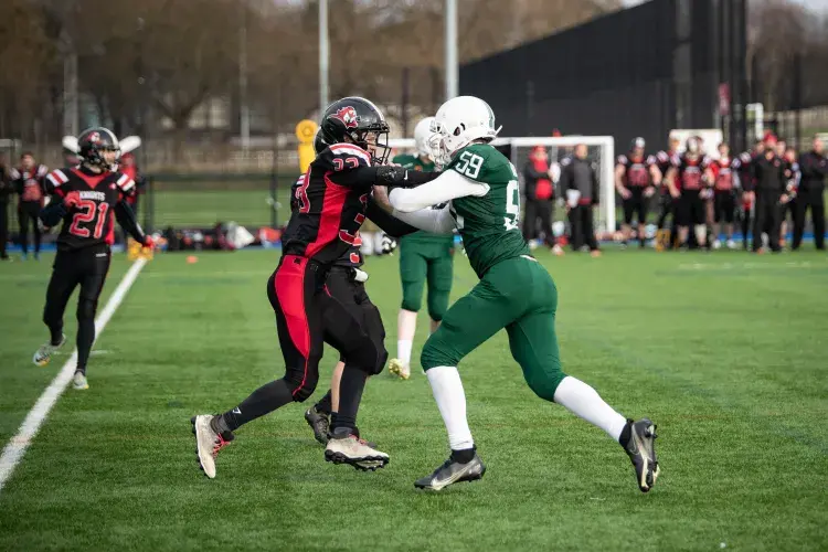 2 people playing american football, tackling each other