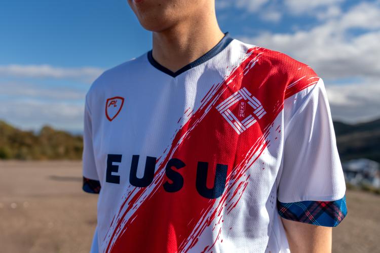 white sports kit with red diagonal line and logo