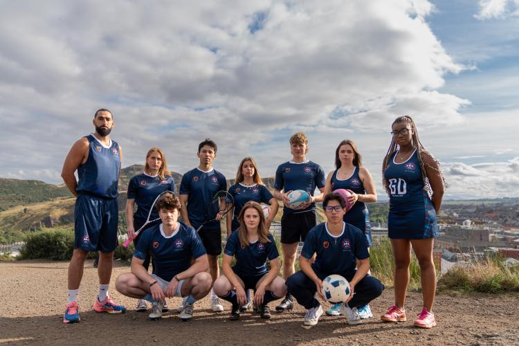 group photo on calton hill in edinburgh , 10 people in kit holding sports equipment