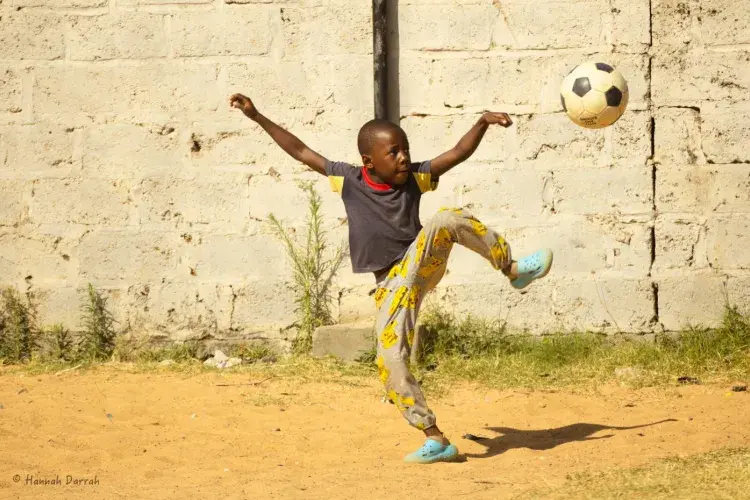 child kicking football in Zambia