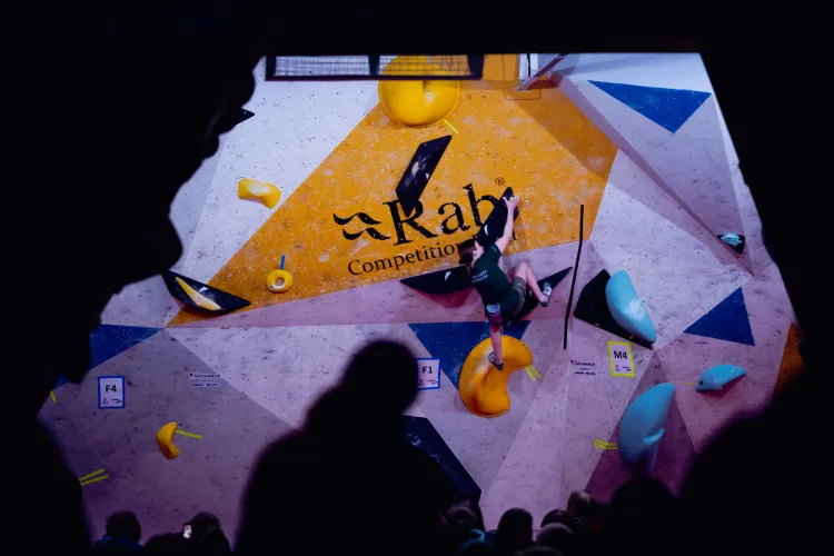zoomed out climbing wall with woman bouldering