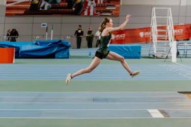 women running up to long jump