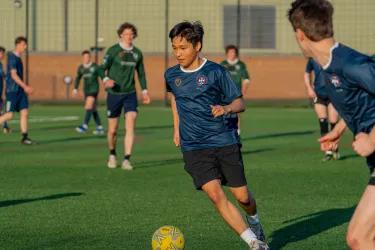 boy playing football in blue shirt