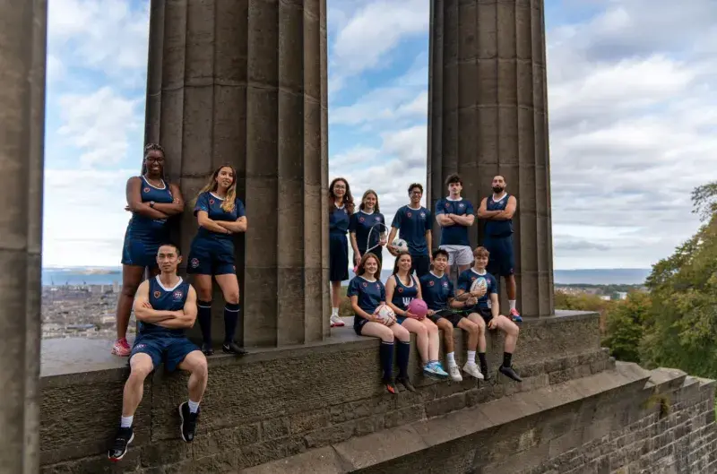 a group of people in sports kit on calton monument