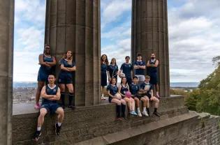 a group of people in sports kit on calton monument