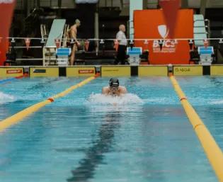 man swimming competition in pool lane
