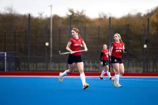 woman playing hockey in red kit