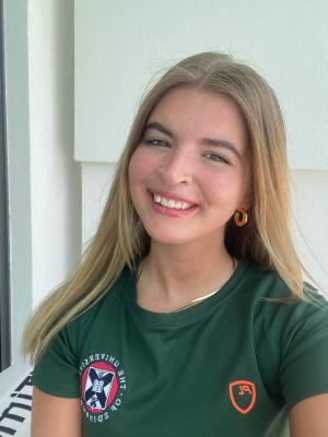 Selfie of women with blonde hair wearing green University of Edinburgh top