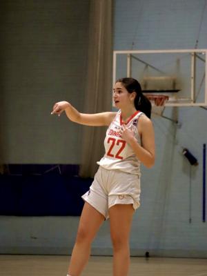 Women throwing a basketball indoors