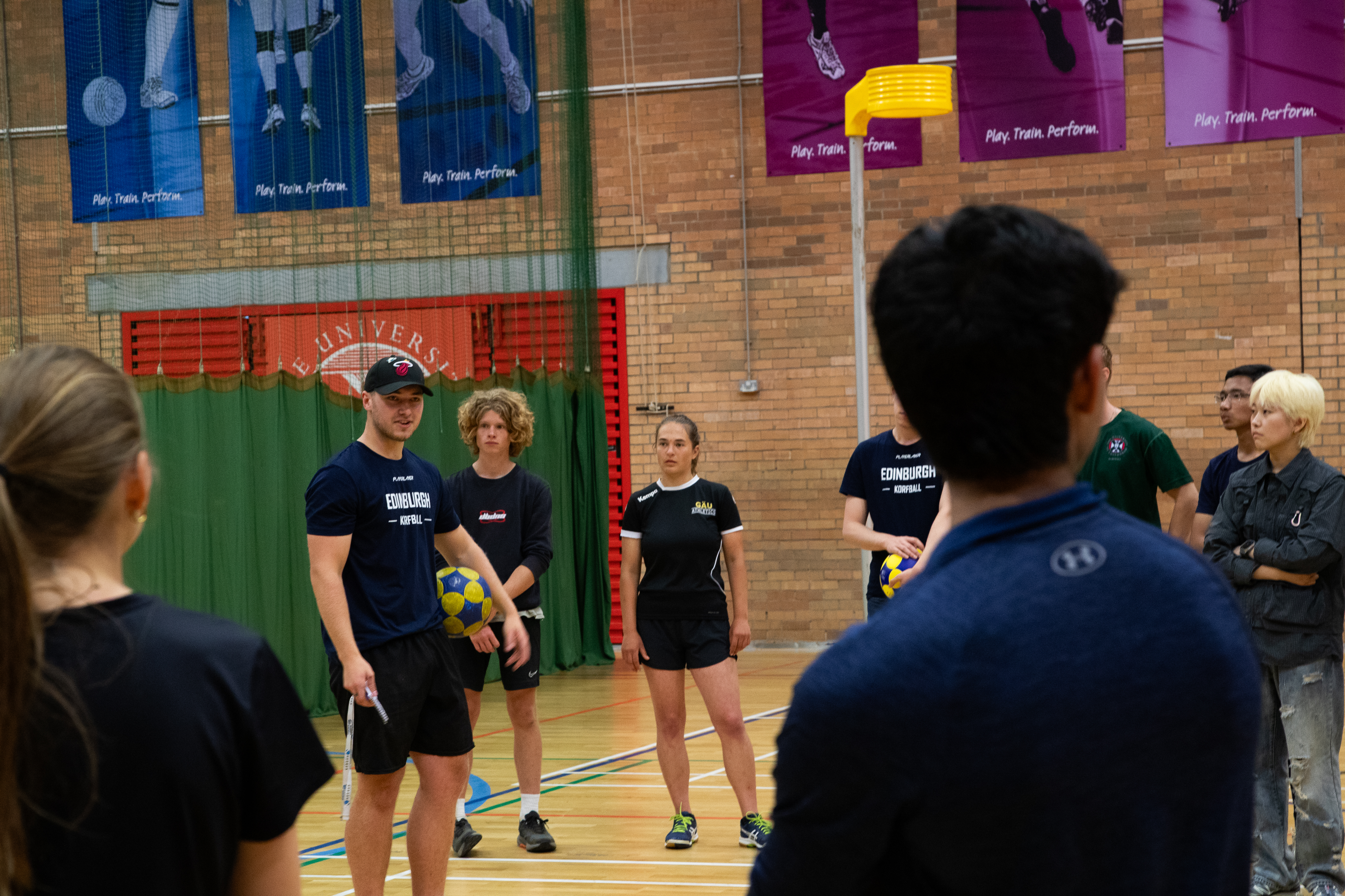 Student sport volunteer coaching korfball in Pleasance sports hall