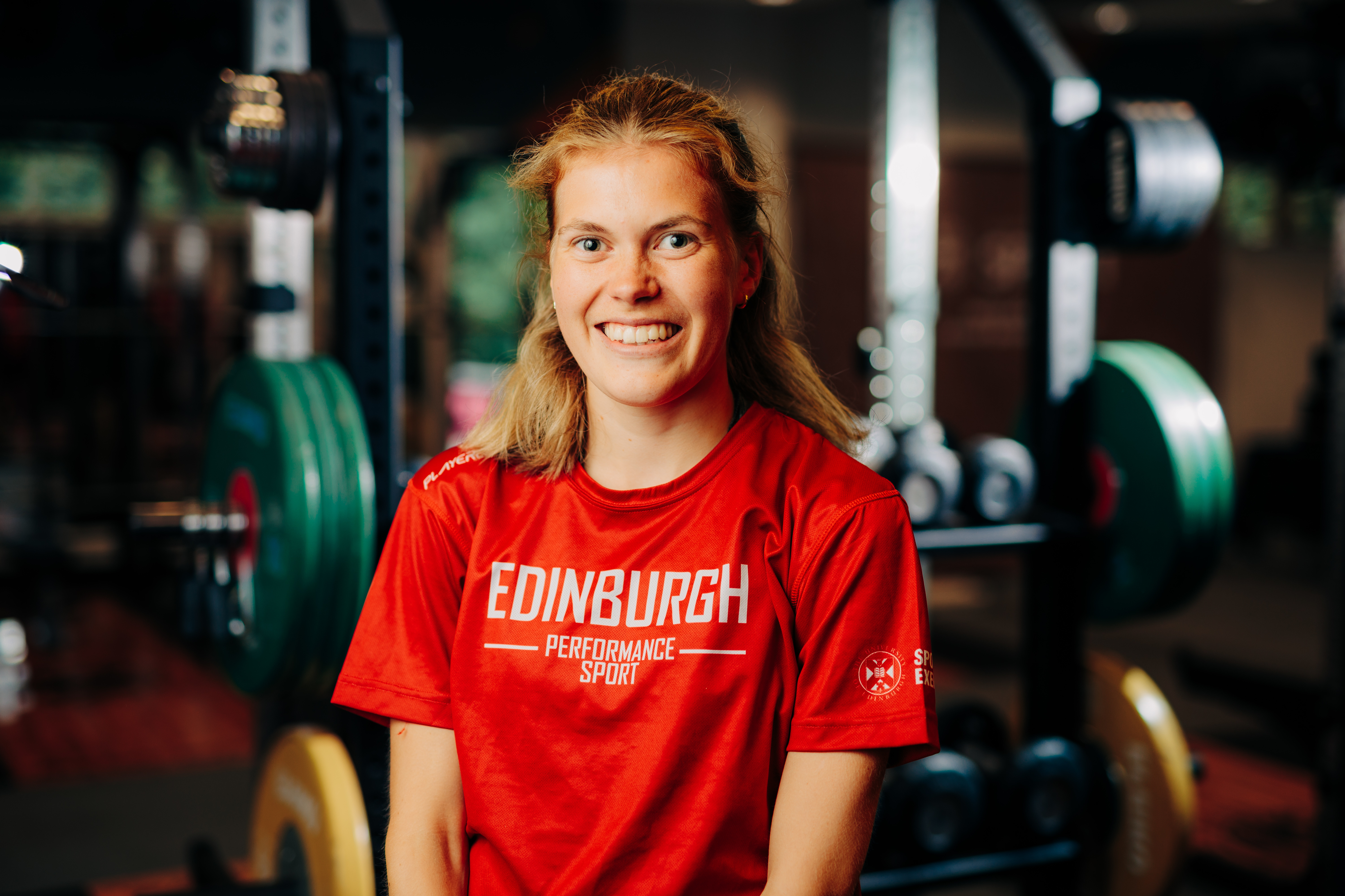 Image of sport scholar Megan Keith smiling with gym in background