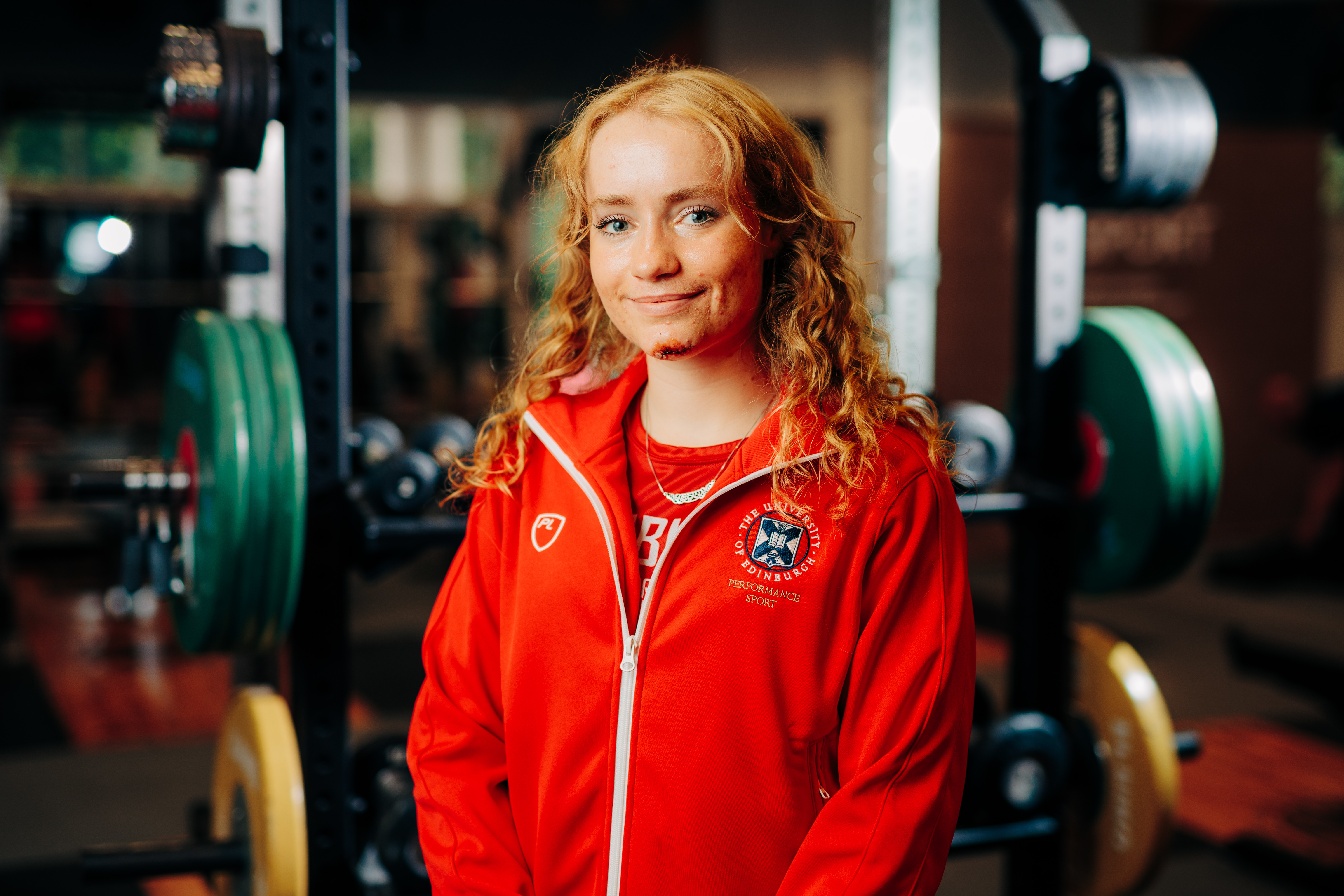 Image of sport scholar Alyson Bell smiling with gym in background