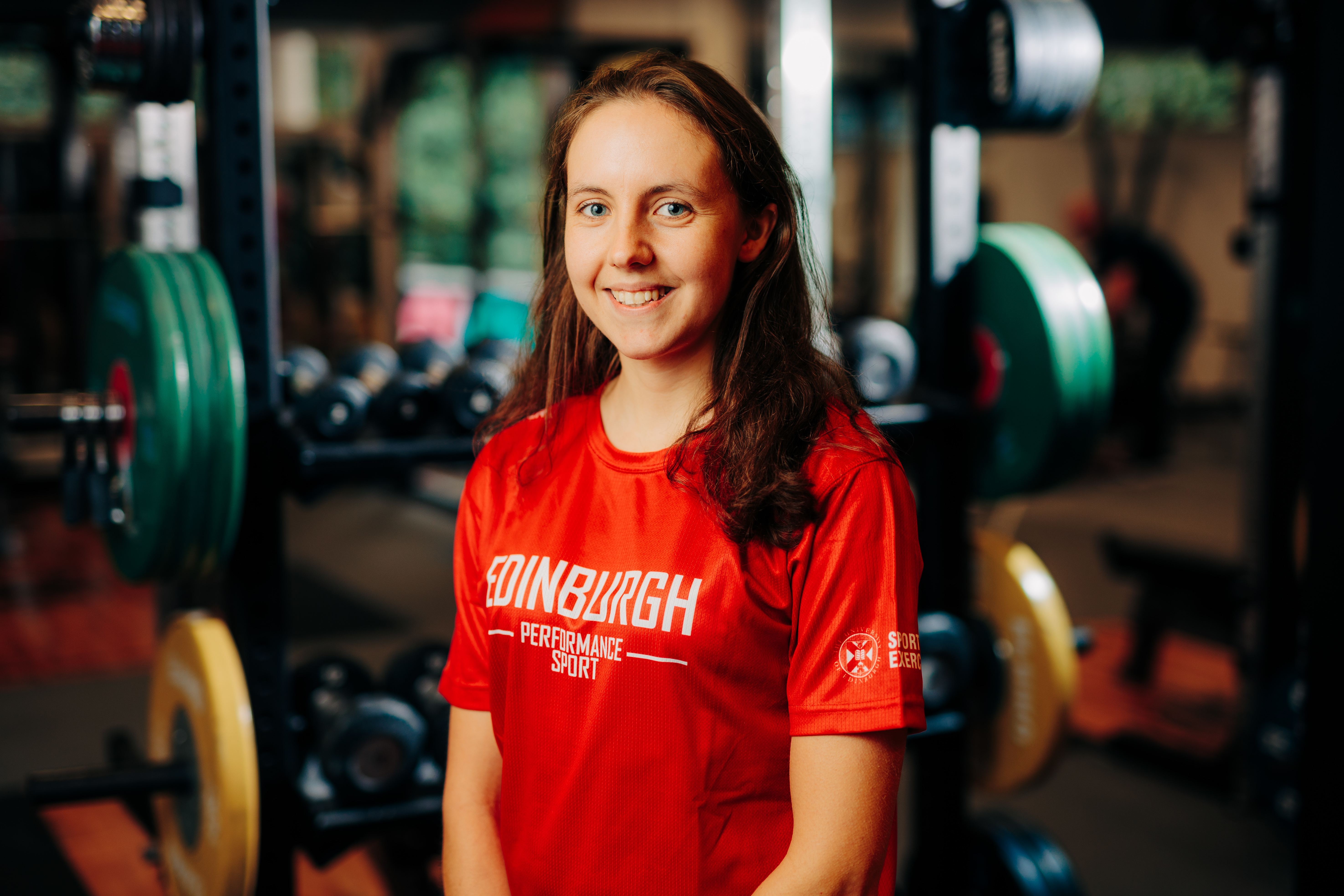 Image of sport scholar Fiona Bunn smiling with gym in background